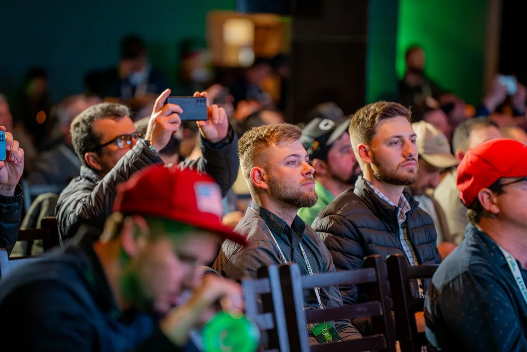 Participantes na plateia, um deles filma a palestra com o celular
